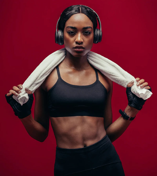 shows a fit and beautiful African American woman in fitness clothing wearing headphones