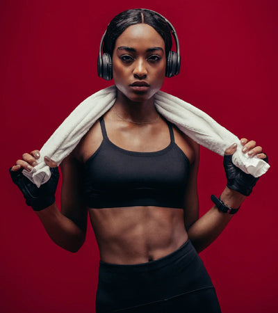 shows a fit and beautiful African American woman in fitness clothing wearing headphones